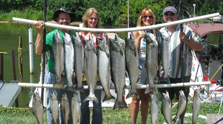 Group of People Standing With Fish They Caught